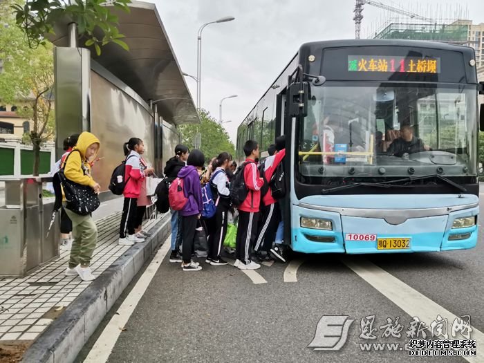 學生在公交站臺上車。